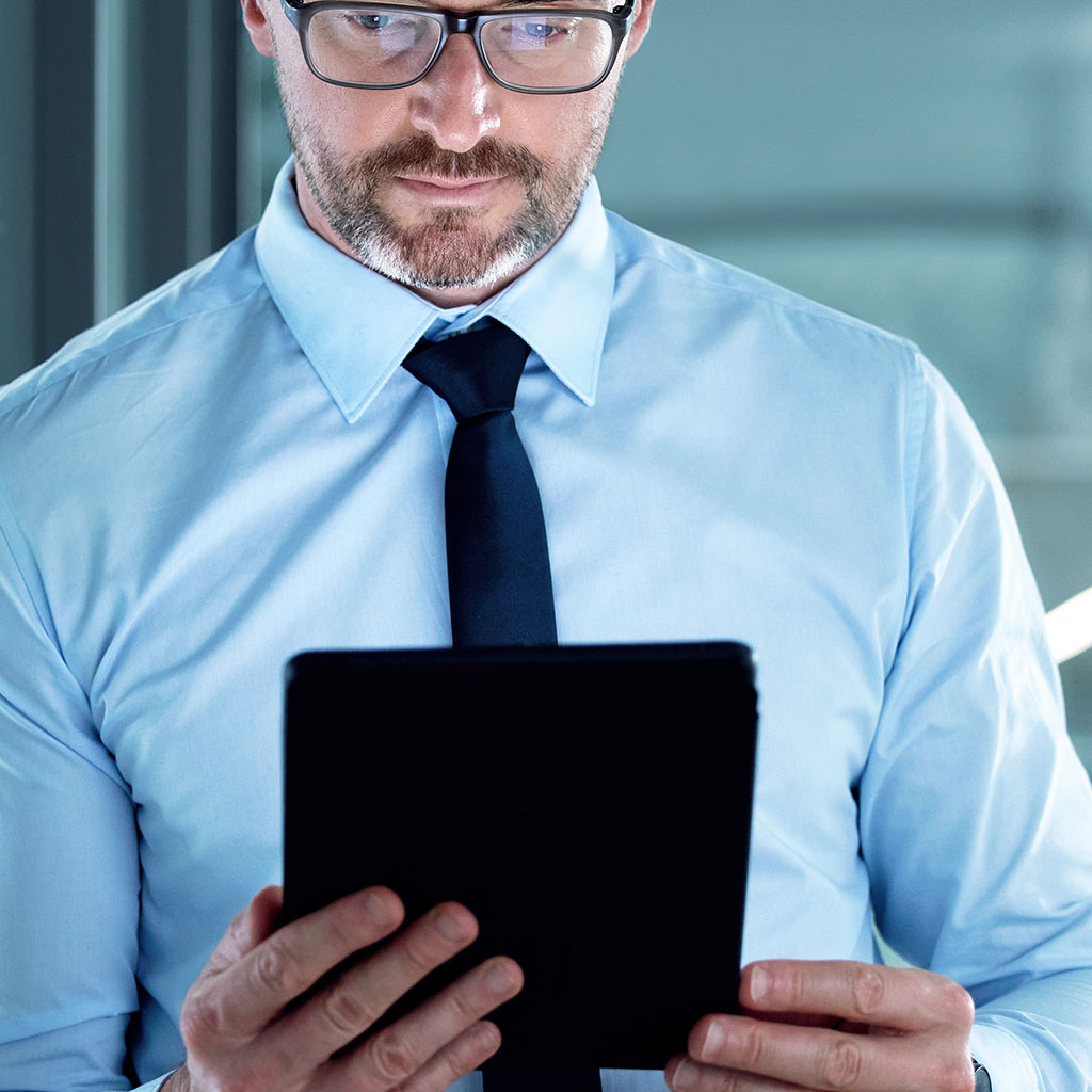 Man reading on a tablet, representing a customer engaging with a content marketing agency's work.