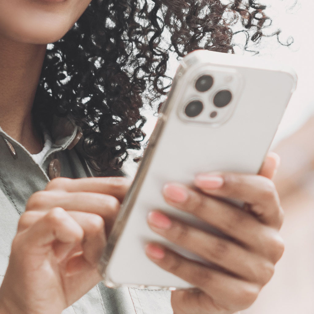 Close-up of a customer holding a smartphone, representing a shopper reached by our e-commerce services.