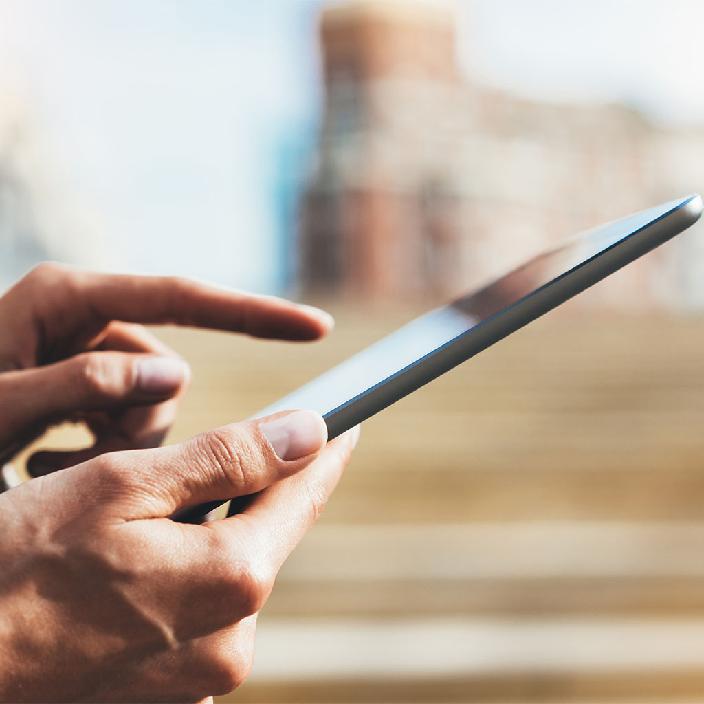 Close-up of a customer checking a smartphone outdoors, representing a shopper reached by ecommerce PPC ads.