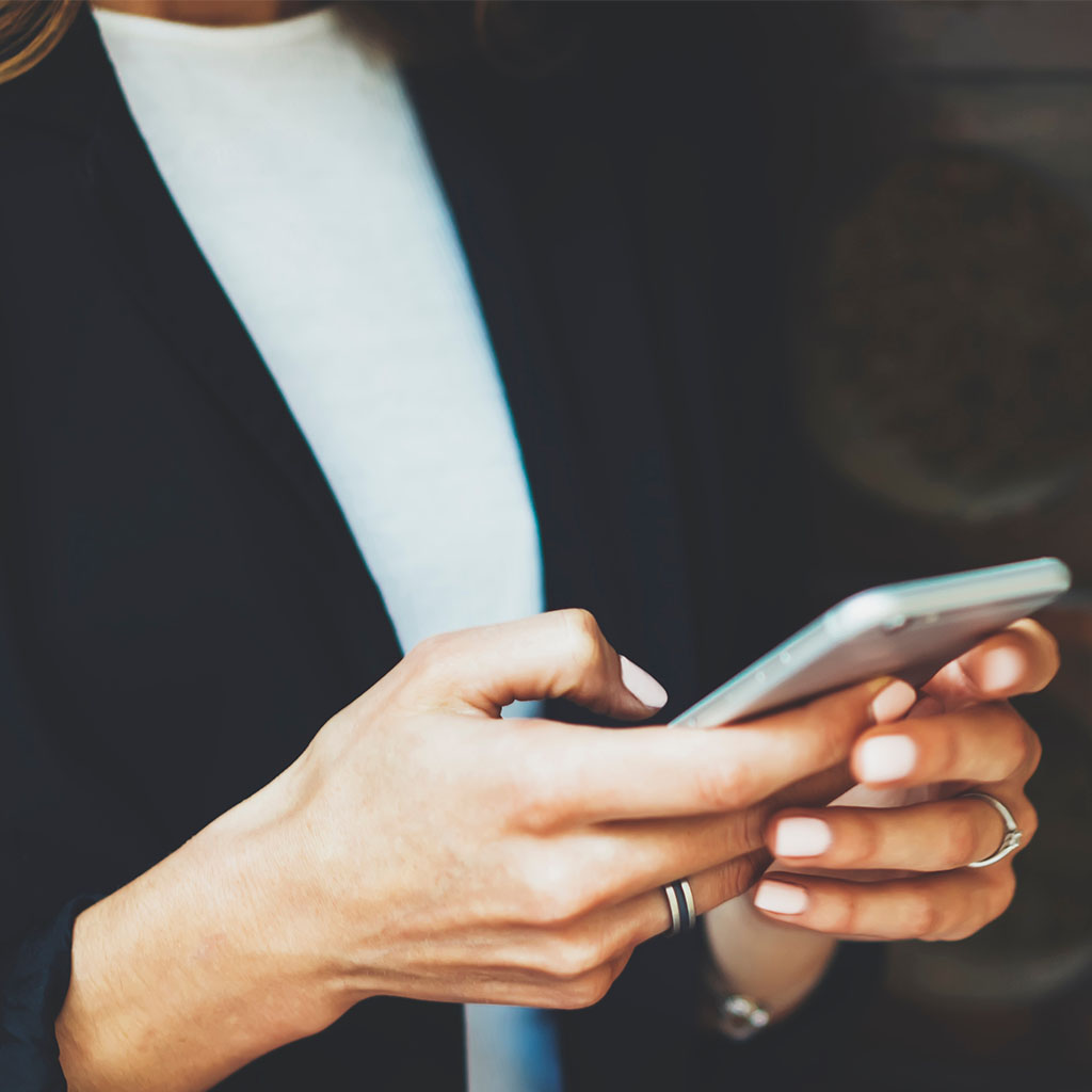 Hand tapping a smartphone with a dark screen, representing a customer engaging with email on mobile.