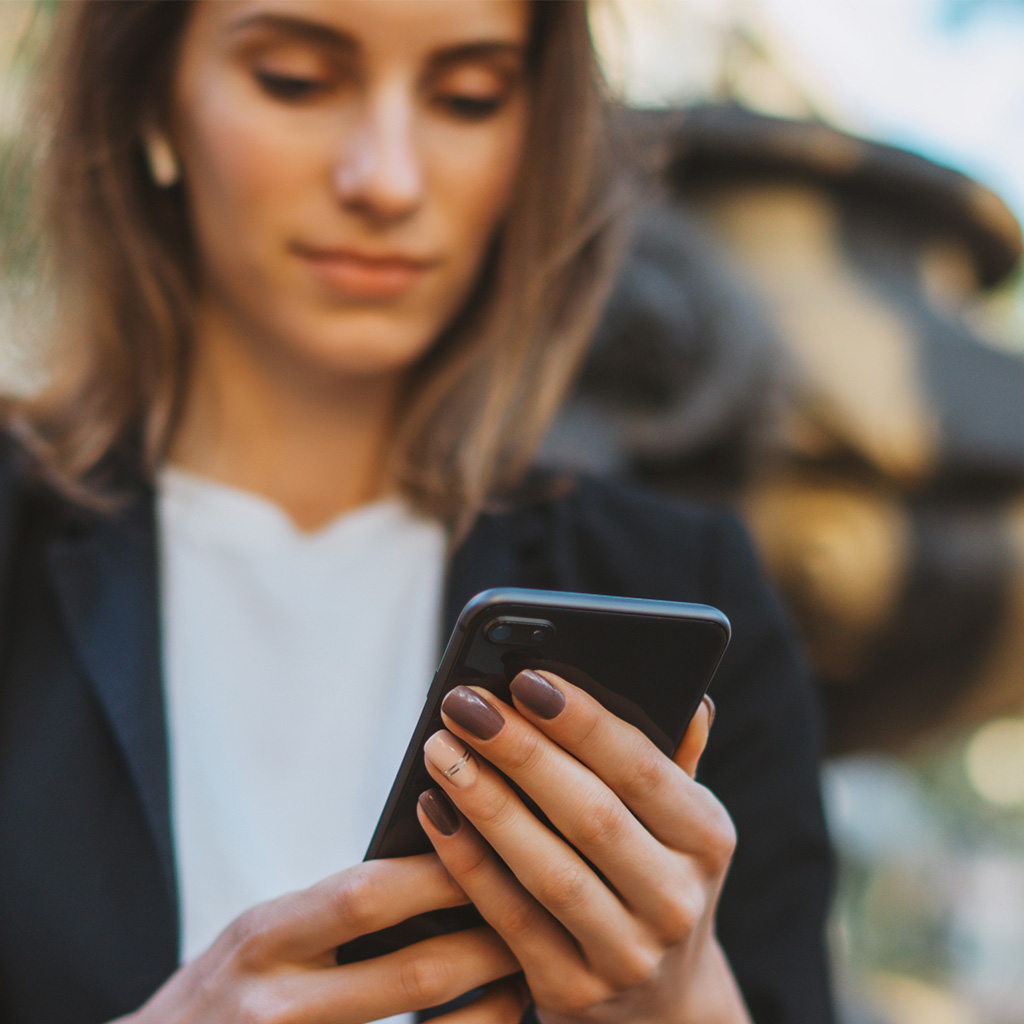 Business professional checking a phone, representing a client engaging with our HubSpot development services.