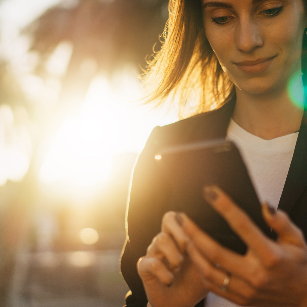 Business professional checking a phone, representing a client engaging with our marketing consultant services.