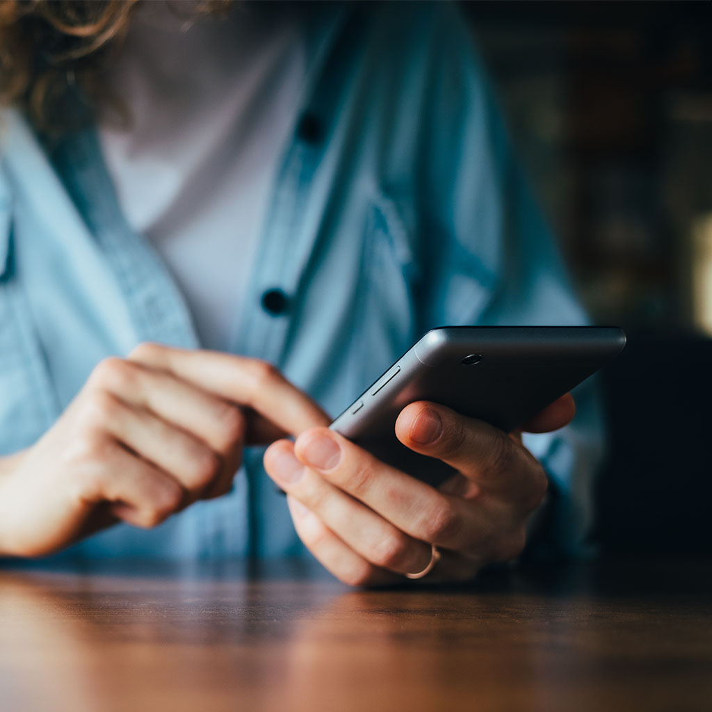 Business professional checking a phone, representing a client monitoring their reviews and reputation.