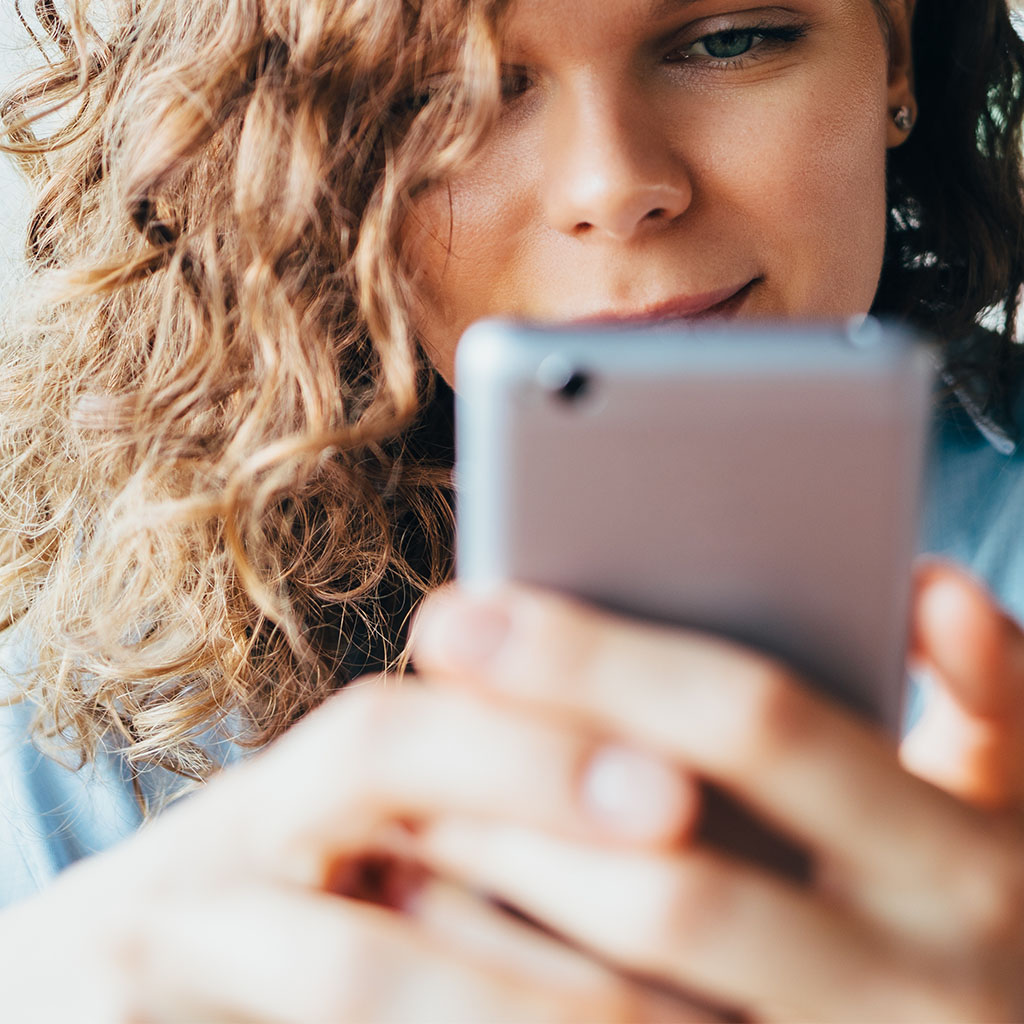 Close-up of a person checking a website on their phone, representing a visitor to a mobile-friendly site built by our website designer.